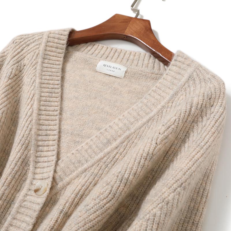 Close-up detail of women's cropped V-neck cardigan showing knit texture and button placket