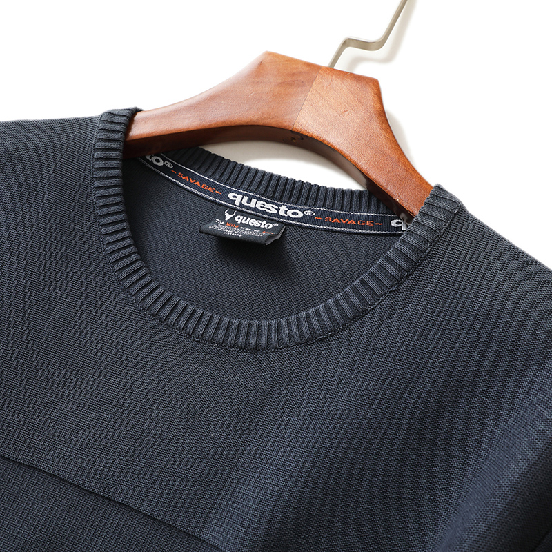 Stone-washed crewneck sweater on hanger showing neck label and factory details