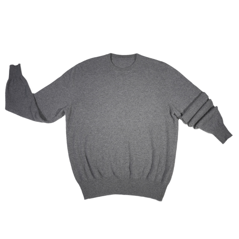 Side view of bulk men's 12GG cashmere crew neck sweater in grey showing ribbed cuffs and relaxed pullover silhouette